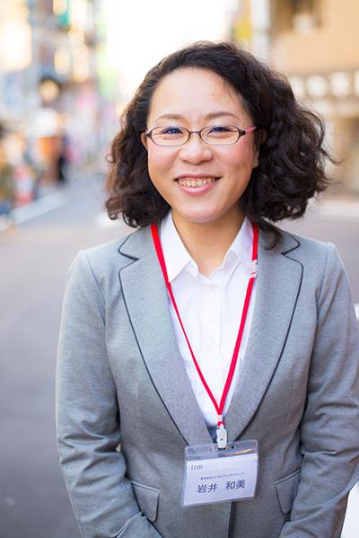 ism参加者・岩井和美のポートレート。ismの名札を首から下げて街中で撮影された写真
